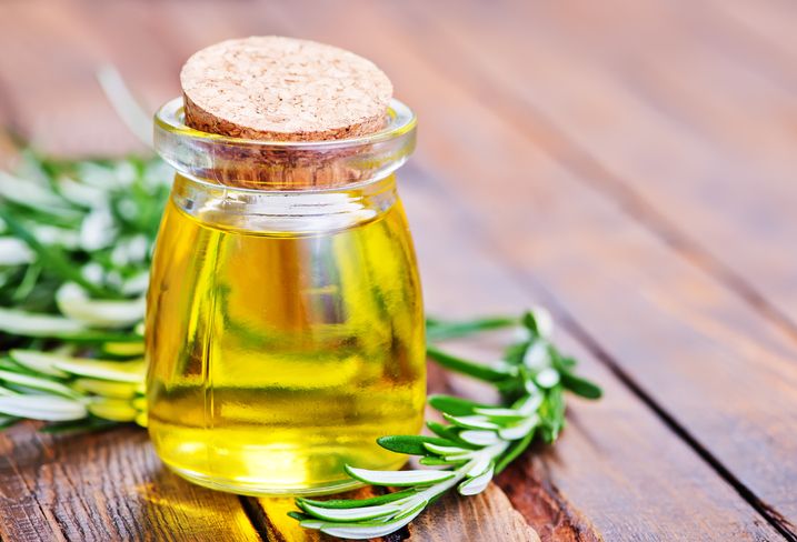 rosemary oil in glass bottle and on a table