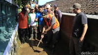 Warga dibantu puluhan relawan dari Masyarakat Relawan Indonesia (MRI) Kabupaten Bandung, Aksi Cepat Tanggap (ACT), BPBD, PMI Kabupaten Bandung, Basarnas, dan organisasi masyarakat. Mereka membersihkan lumpur di jalan dan rumah. Pool/Wisma Putra.