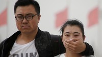 Tak menggunakan masker, seorang pria menutup hidung rekanw anitanya menggunakan tangan untuk menghindari dampak badai debu. REUTERS/Jason Lee.