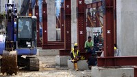 Sejumlah pekerja beristirahat dengan duduk-duduk di sekitar tiang penyangga jalur MRT. Pool/Williams Prayoga.