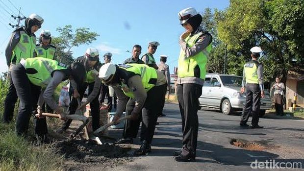 Polwan Cantik Polres Banyuwangi Tambal Jalan Berlubang