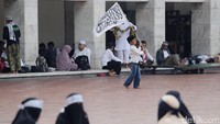 Seorang anak mengibarkan bendera.