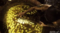 Tahu dimasukkan ke dalam tungku panas yang di dalamnya telah terdapat air kunyit. Air kunyit berfungsi sebagai pengganti formalin dalam produksi tahu. Dan proses ini yang sekaligus memberi warna kuning terhadap tahu. Pool/Muamar Khalid Affandi.