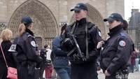 Polisi bersenjata lengkap berjaga di sekitar Notre Dame de Paris.