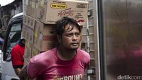 Seorang pedagang mengangkut barang dagangannya. Pool/Rima Olyvia.