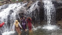 Mereka tampak asyik mandi-mandi dan bermain air di bawah derasnya aliran Air Terjun Rayap. Airnya berasal dari pegunungan, jernih dan segar! (Datuk Haris/detikTravel)