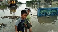 Dua bocah sedang menyusuri wilayah banjir.