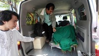 Jenazah mulai diturunkan dari ambulans.