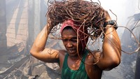 Seorang warga terlihat mengangkut gulungan tembaga sisa kabel listrik. REUTERS/Erik De Castro.