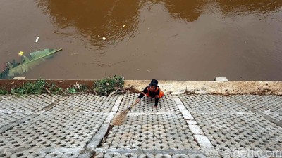 Pasukan Oranye Bersihkan Tepi Kali Ciliwung