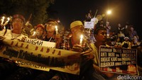 Ada yang duduk, berdiri, dan bergandengan. Selain menyanyi lagu kebangsaan, mereka mendengarkan orasi.