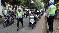 Polisi menghentikan pengendara sepeda motor yang melintas untuk diperiksa kelengkapan suratnya.