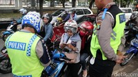 Dua orang polisi memeriksa surat-surat kendaraan.