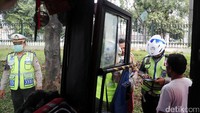 Tidak hanya sepeda motor, angkutan umum juga diberhentikan untuk diperiksa kelengkapan suratnya.