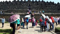 Walaupun udara panas, pengunjung tetap semangat wisata di candi bersejarah ini. Mereka mengenakan topi dan payung untuk berlindung dari sengatan matahari (Kurnia/detikTravel)