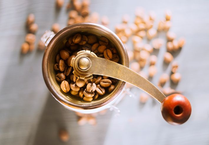 Two coffee cups, coffee pot and wooden cutting board in the kitchen, selective focus