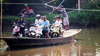 Perahu eretan menyeberangkan pengendara sepeda motor.