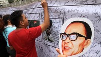 Setelah membubuhkan tanda tangan, warga yang berpartisipasi kemudian diberi topeng pahlawan. 