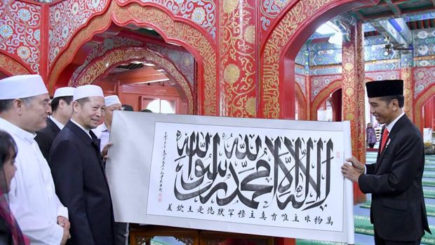 Presiden Jokowi memberikan kaligrafi ke Imam Masjid.