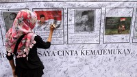 Warga membubuhkan tanda tangan di poster bergambar para pahlawan di arena car free day (CFD) di Bundaran Hotel Indonesia (HI), Jakarta Pusat, Minggu (14/5/2017).
