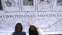 Dua orang warga membubuhkan tanda tangan.