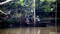 Sejumlah pengendara sepeda motor menaiki perahu eretan di Kali Angke, Jakarta Utara, Minggu (14/5/2017).