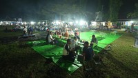 Setelah memesan traveler tak perlu menunggu berdiri di depan penjual. Traveler bisa duduk di tengah lapangan. Sejumlah terpal, meja, dan dan lampu gantung sudah siap untuk digunakan untuk menikmati makanan yang dipesan (Artho/CNN)