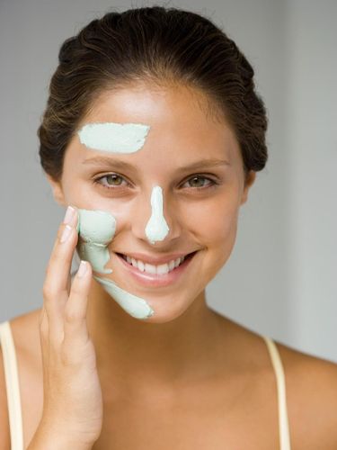 Woman applying facial mask