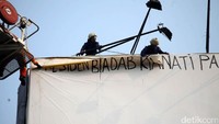 Petugas pemadam kebakaran mencopot baliho yang dipasang Agustinus.