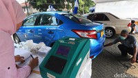Petugas uji emisi saat melakukan pengujian asap kendaraan bermotor.