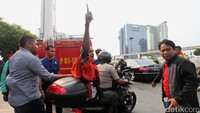 Agustinus sempat mengacungkan jari telunjuknya saat dibawa ke Polsek Tanah Abang menggunakan sepeda motor.