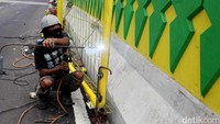 Pekerja tengah menyelesaikan pekerjaan pembuatan pagar.