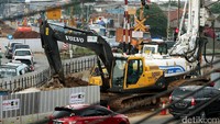 Alat berat mengeruk tanah untuk pembangunan flyover.