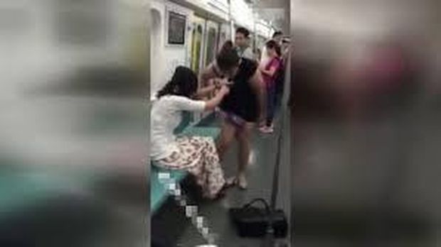 Dua wanita saling merobek baju di kereta di China. 
