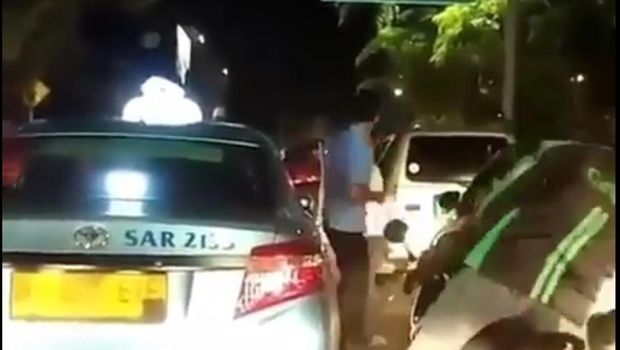 Sopir taksi dan pengemudi mobil berkelahi di tengah jalan. 