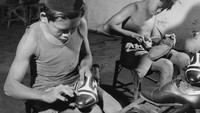 Dalam foto, nampak dua bocah sedang menyemir sepatu di sebuah toko pada tahun 1955. Horace Bristol/Getty Images.