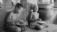 Dua boacah tengah menikmati makan siang di suatu kawasan di Bali tahun 1956. Three Lions/Getty Images.