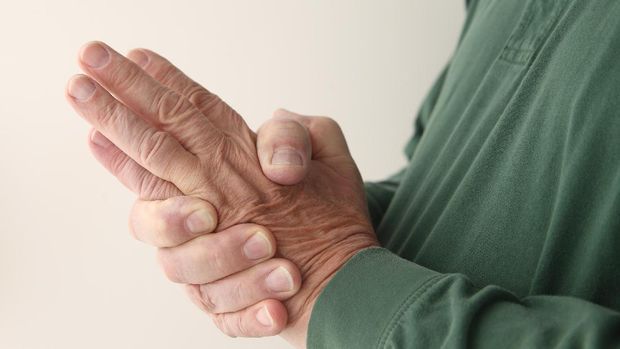 a man tries to restore feeling in his hand by squeezing