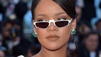 Rihanna melengkapi penampilannya dengan kaca mata hitam. Foto: Francois Durand/Getty Images