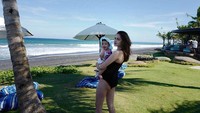 Yasmine Wildblood tengah menggendong anaknya di pantai dengan mengenakan bikini hitam. Foto: Instagram Yasmine Wildblood