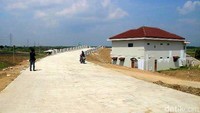 Pengendara sepeda motor melintas di depan rumah juragan warteg yang masih berdiri kokoh di proyek tol Pejagan-Pemalang. Imam Suripto/detikFoto.