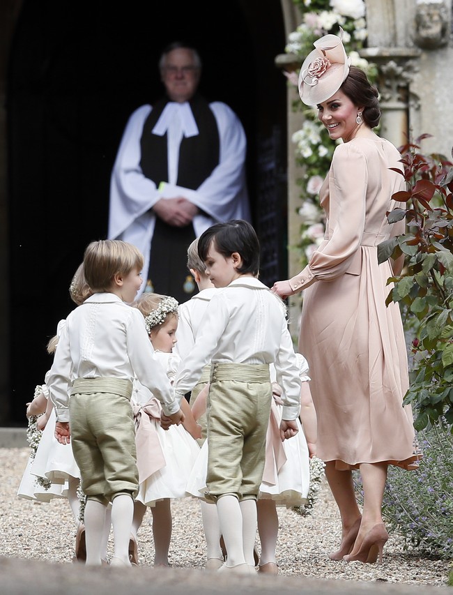 Senyum Kate Middleton saat menuntun bridesmaid dan page boy memasuki Gereja St. Mark di Berkshire, Inggris. Foto: Getty Images
