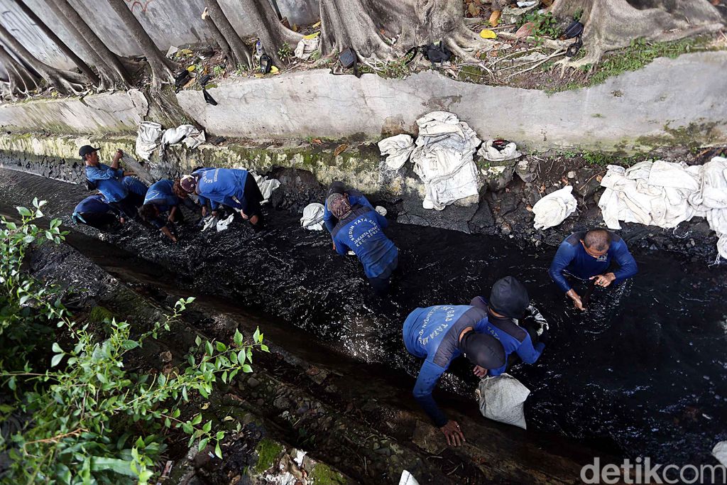 Inilah aksi pasukan biru dari Dinas Tata Air DKI Jakarta, saat nyemplung ke got hitam untuk mengangkut kotoran lumpur yang menyumbat saluran air, di Jalan Pal Putih, Kramat Pulo, Senen, Jakarta Pusat, Selasa (23/05/2017).
