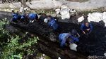 Pasukan Biru Nyemplung ke Got Hitam untuk Bersihkan Lumpur