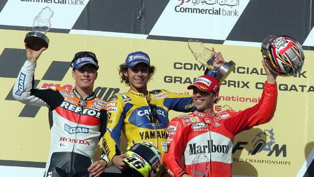 Italian rider and world champion Valentino Rossi (C) (Yamaha) celebrates after winning the Qatar Grand Prix World Championships with first runner Nicky Hayden of the USA (L) (Repsol Honda) and third place winner Loris Capirossi of Italy (Ducati) 08 April 2006, at the Losail International Circuit in Doha. The Italian Yamaha ace's second successive victory here was gained at the expense of Nicky Hayden of the United States with Rossi's compatriot Loris Capirossi, winner of the season-opener in Spain last month, taking third. AFP PHOTO/KARIM JAAFAR / AFP PHOTO / KARIM JAAFAR
