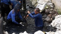 Pasukan biru membersihkan saluran air di Jalan Pal Putih, Kramat Pulo, Senen, Jakarta Pusat, Selasa (23/5/2017).