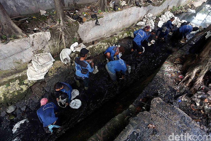 Inilah aksi pasukan biru dari Dinas Tata Air DKI Jakarta, saat nyemplung ke got hitam untuk mengangkut kotoran lumpur yang menyumbat saluran air, di Jalan Pal Putih, Kramat Pulo, Senen, Jakarta Pusat, Selasa (23/05/2017).