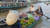 Selain belanja, traveler juga bisa menjajal ikut naik ke perahu pedagang. Mereka akan mengajarkan cara naik dan turun perahu dengan ramah (Kurnia/detikTravel)