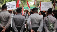 Warga Pulau Pari berorasi di depan barisan polisi yang melakukan penjagaan.