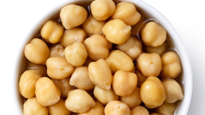 Cooked chickpeas in white bowl isolated on white from above.